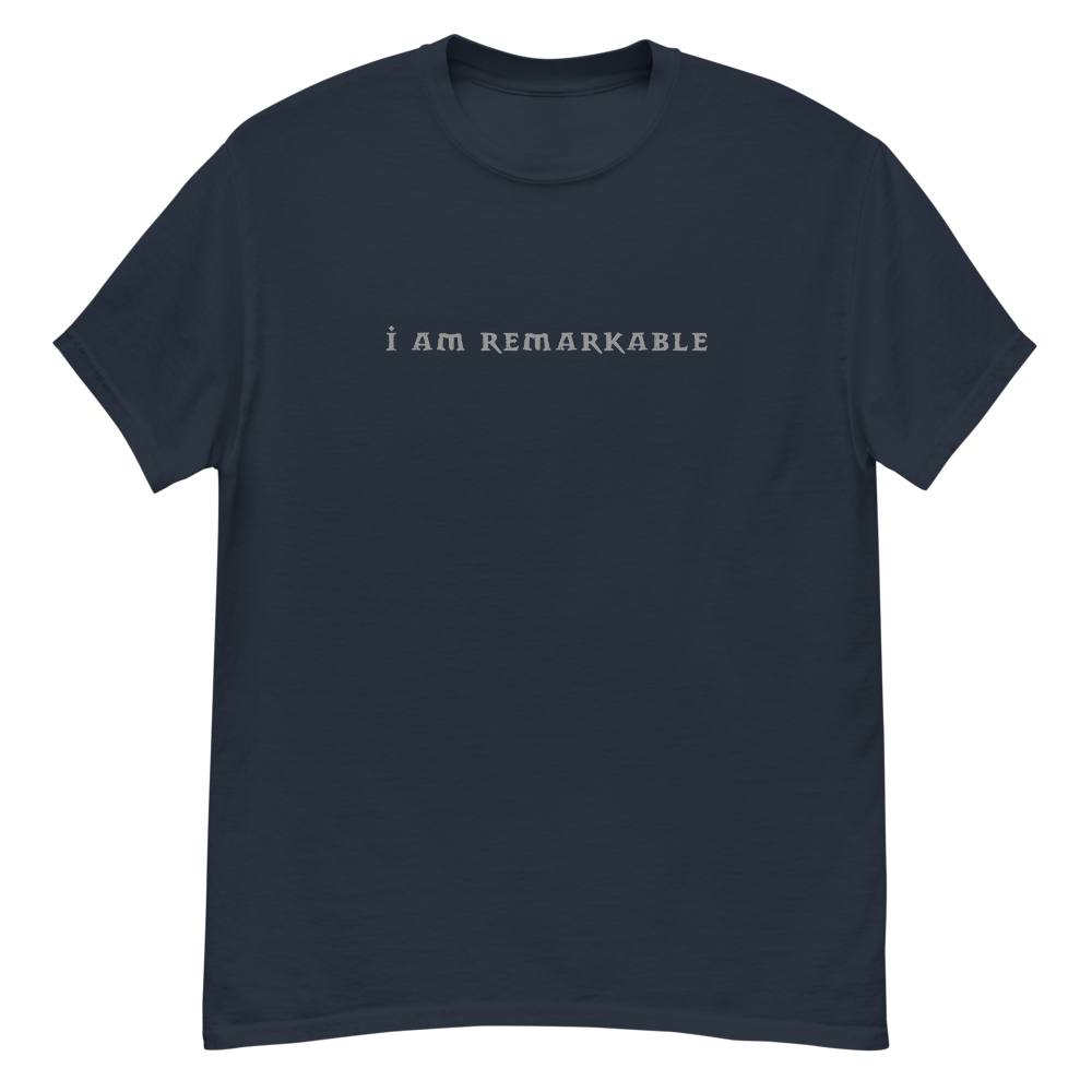 "I am remarkable" printed on a navy unisex classic tee laying on a flat surface