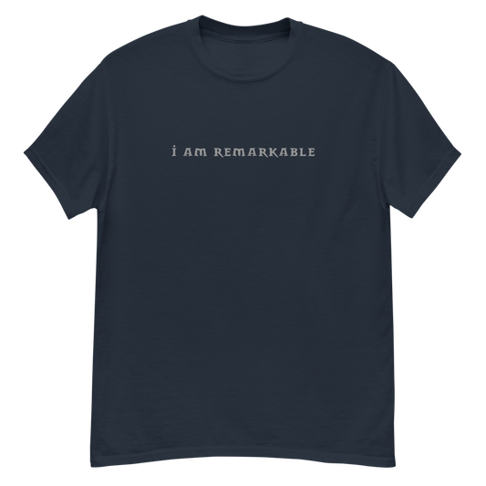 "I am remarkable" printed on a navy unisex classic tee laying on a flat surface