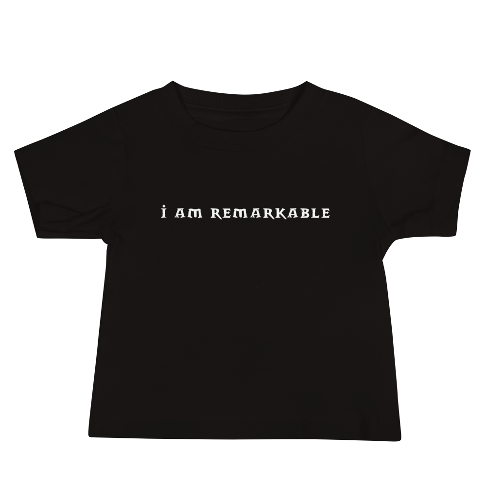 "I am remarkable" printed on a black baby jersey short sleeve tee laying on a flat surface