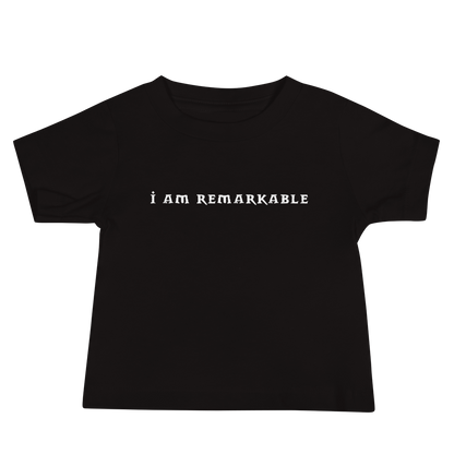 "I am remarkable" printed on a black baby jersey short sleeve tee laying on a flat surface