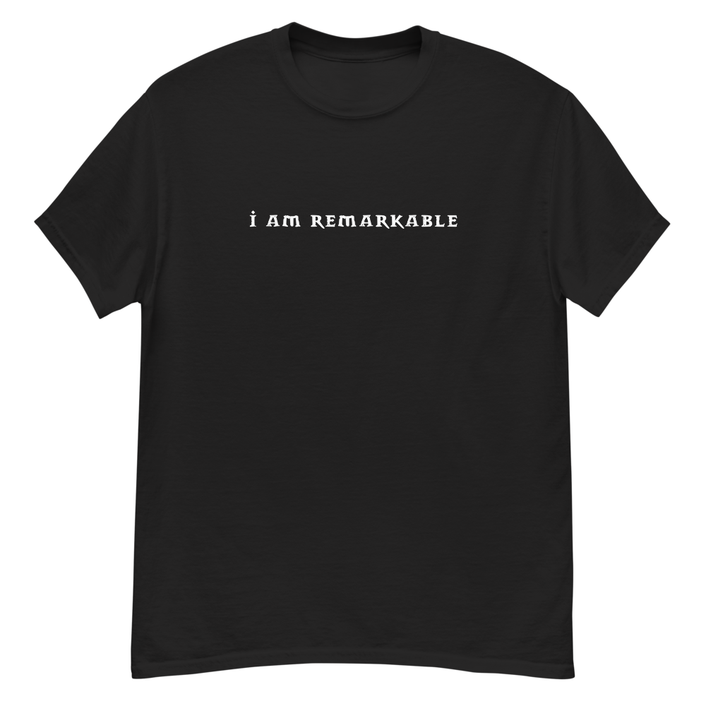 "I am remarkable" printed on a black unisex classic tee laying on a flat surface