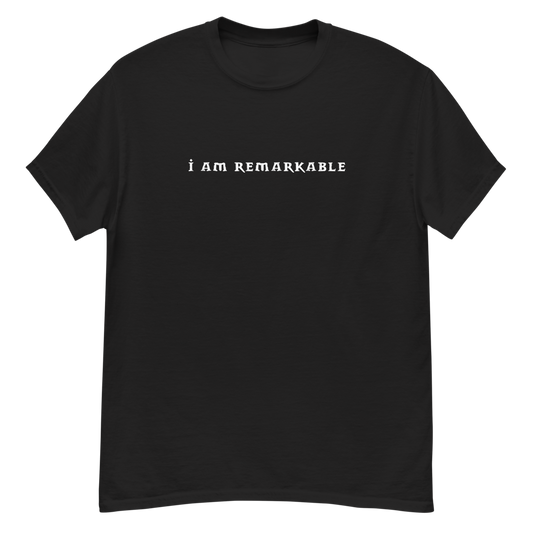 "I am remarkable" printed on a black unisex classic tee laying on a flat surface