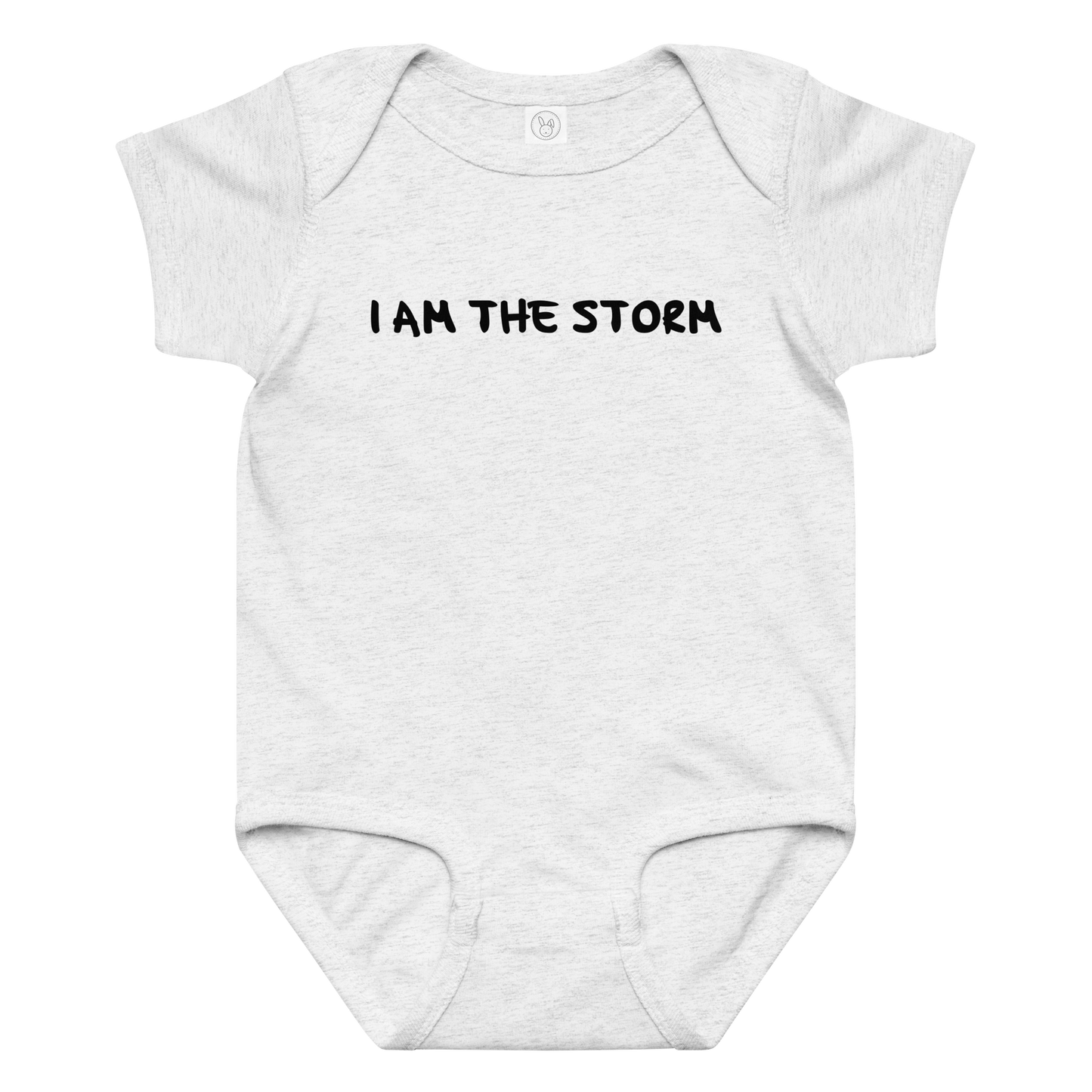"I am the storm" printed on a ash baby jersey bodysuit laying on a flat surface amongst other clothes