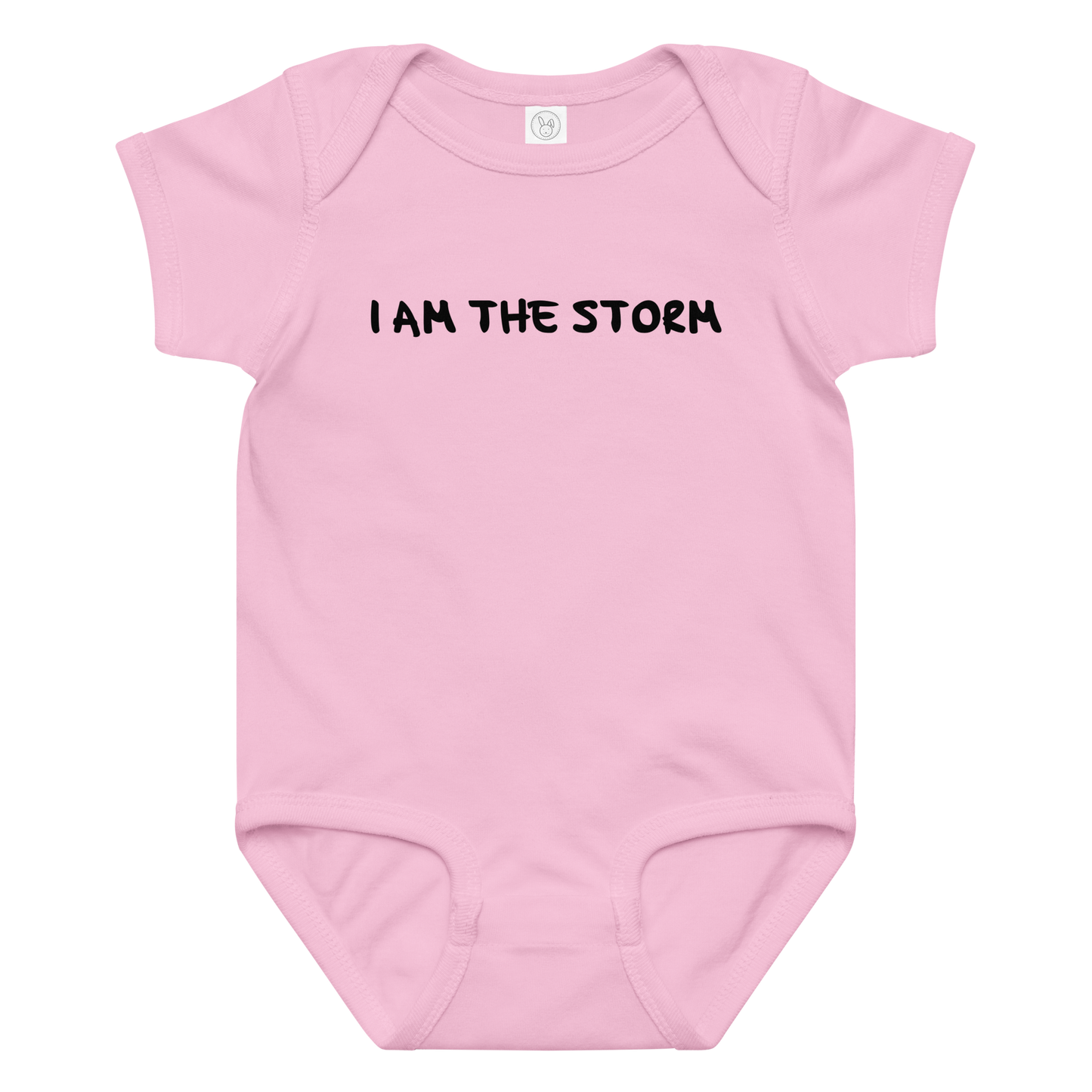 "I am the storm" printed on a pink baby jersey bodysuit laying on a flat surface amongst other clothes