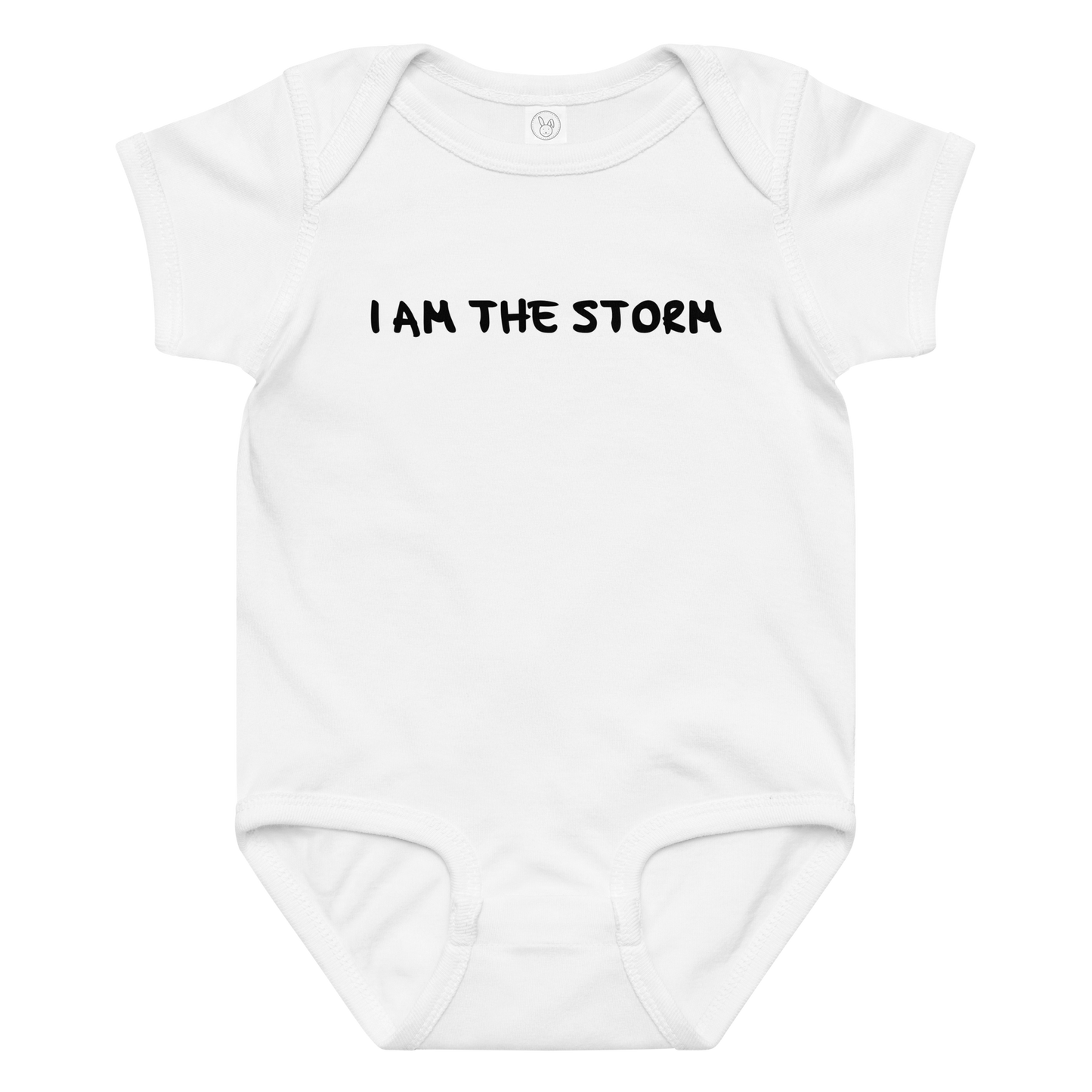 "I am the storm" printed on a white baby jersey bodysuit laying on a flat surface amongst other clothes