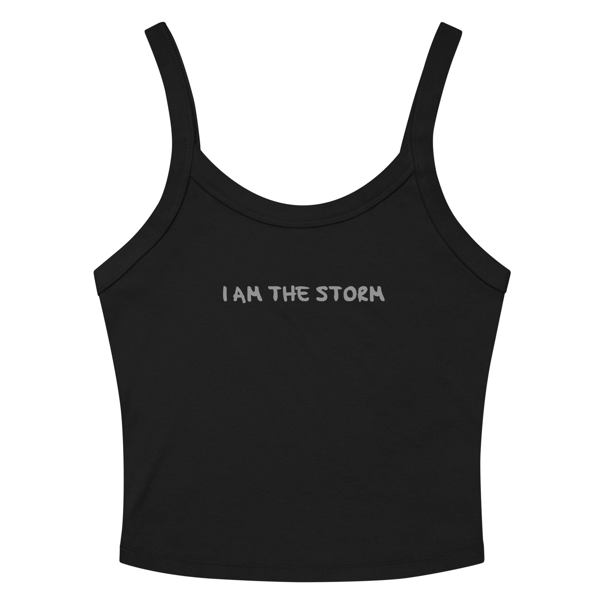"I am the storm" printed on a solid black blend women's micro-rib tanktop laying on a flat surface amongst sunglasses and shorts