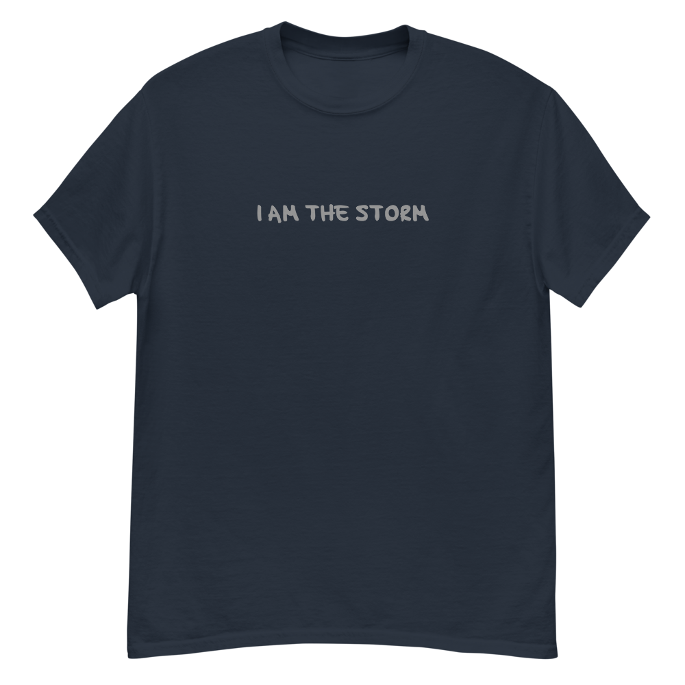 "I am the storm" printed on a navy unisex classic tee laying on a flat surface