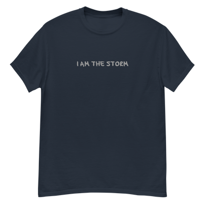 "I am the storm" printed on a navy unisex classic tee laying on a flat surface