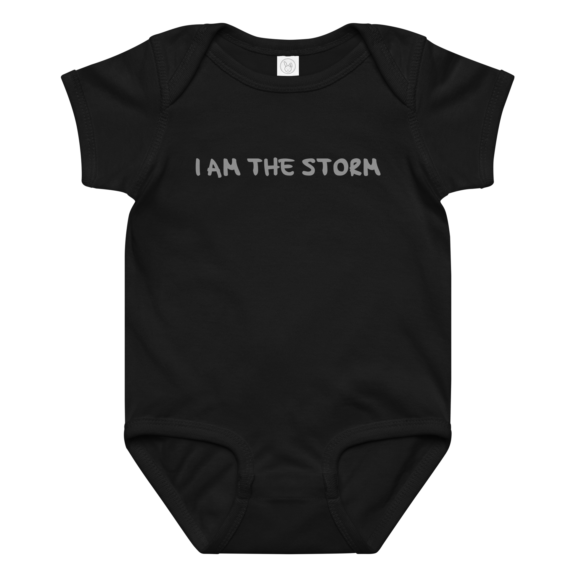 "I am the storm" printed on a black baby jersey bodysuit laying on a flat surface amongst other clothes