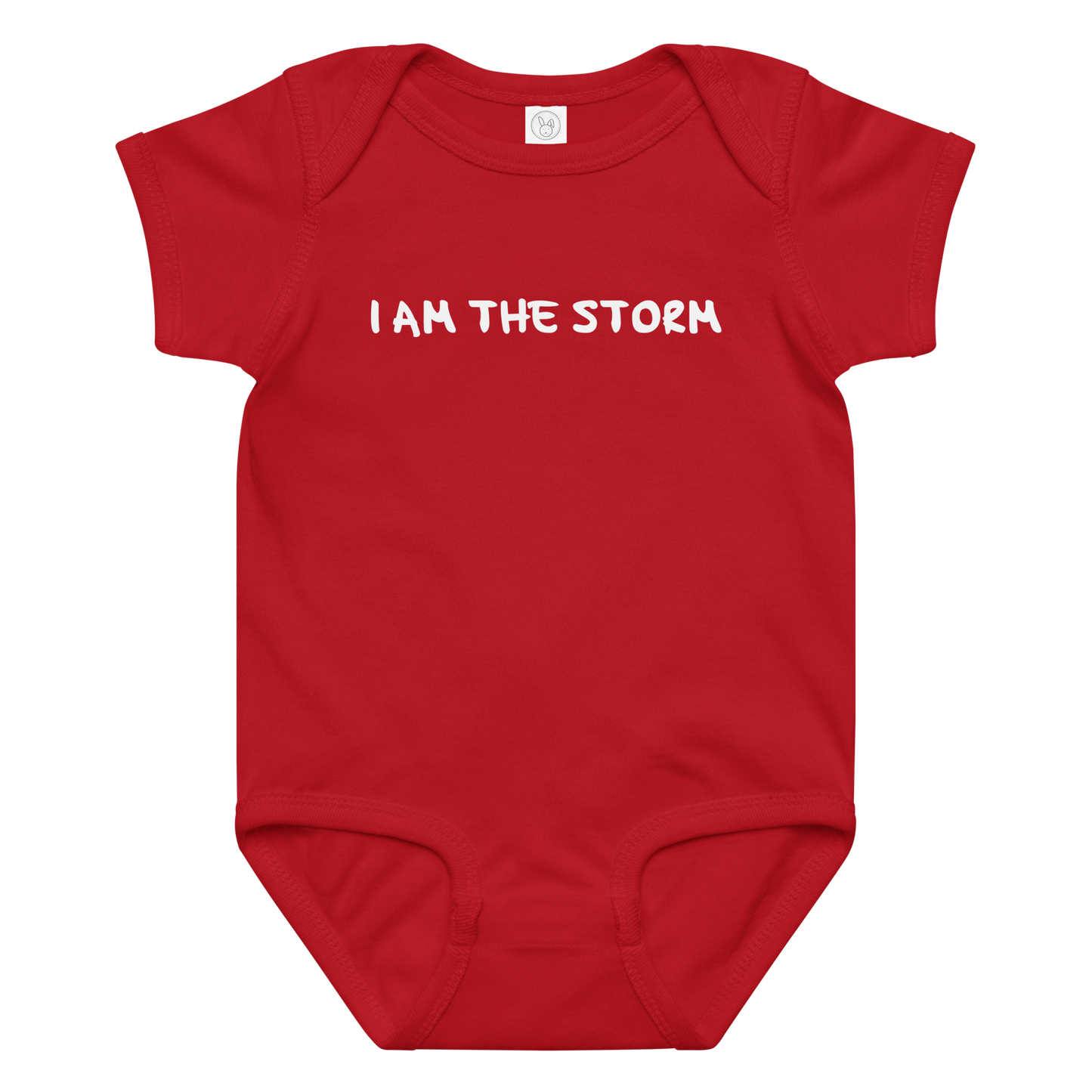 "I am the storm" printed on a red baby jersey bodysuit laying on a flat surface amongst other clothes