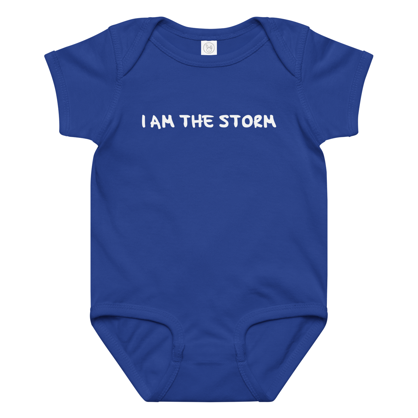 "I am the storm" printed on a royal baby jersey bodysuit laying on a flat surface amongst other clothes