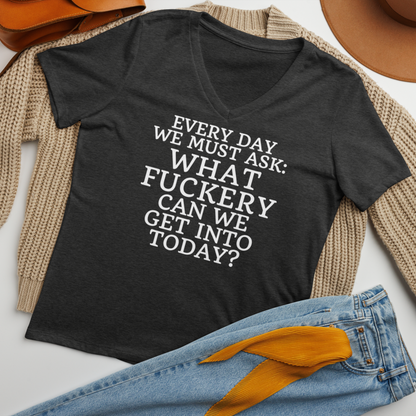 "Every day we must ask: What fuckery can we get into today?" printed on a dark grey heather women's relaxed v-neck t-shirt laying on a flat surface amongst other clothes