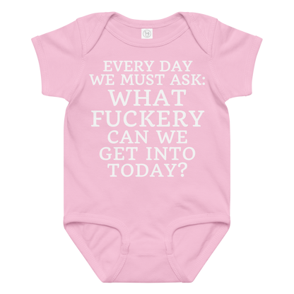 "Every day we must ask: What fuckery can we get into today?" printed on a pink baby jersey bodysuit laying on a flat surface amongst other clothes