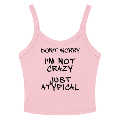"Don't Worry I'm Not Crazy Just Atypical" printed on a solid pink blend women's micro-rib tanktop laying on a flat surface amongst sunglasses and shorts