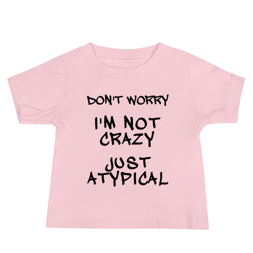 "Don't Worry I'm Not Crazy Just Atypical" printed on a pink baby jersey short sleeve tee laying on a flat surface