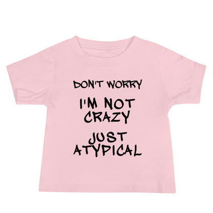 "Don't Worry I'm Not Crazy Just Atypical" printed on a pink baby jersey short sleeve tee laying on a flat surface