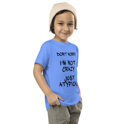 "Don't Worry I'm Not Crazy Just Atypical" printed on a heather columbia blue toddler short sleeve tee worn by a male who is also wearing a knit cap