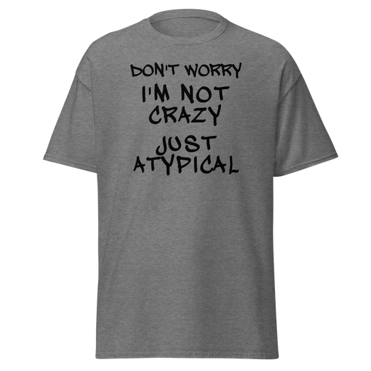 "Don't Worry I'm Not Crazy Just Atypical" printed on a graphite heather unisex classic tee laying on a flat surface