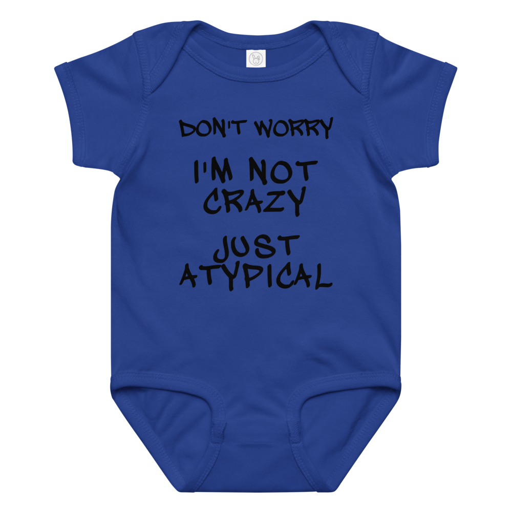 "Don't Worry I'm Not Crazy Just Atypical" printed on a royal baby jersey bodysuit laying on a flat surface amongst other clothes