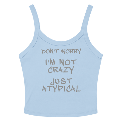 "Don't Worry I'm Not Crazy Just Atypical" printed on a solid baby blue blend women's micro-rib tanktop laying on a flat surface amongst sunglasses and shorts
