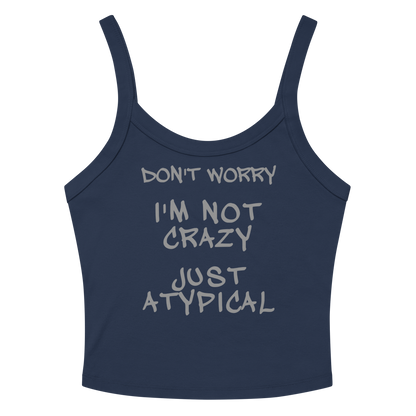 "Don't Worry I'm Not Crazy Just Atypical" printed on a solid navy blend women's micro-rib tanktop laying on a flat surface amongst sunglasses and shorts