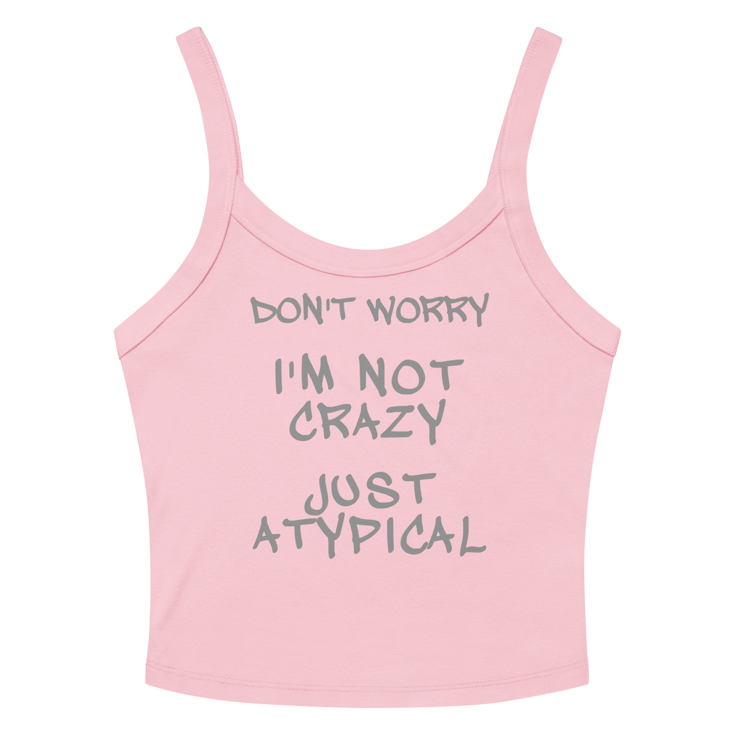 "Don't Worry I'm Not Crazy Just Atypical" printed on a solid pink blend women's micro-rib tanktop laying on a flat surface amongst sunglasses and shorts