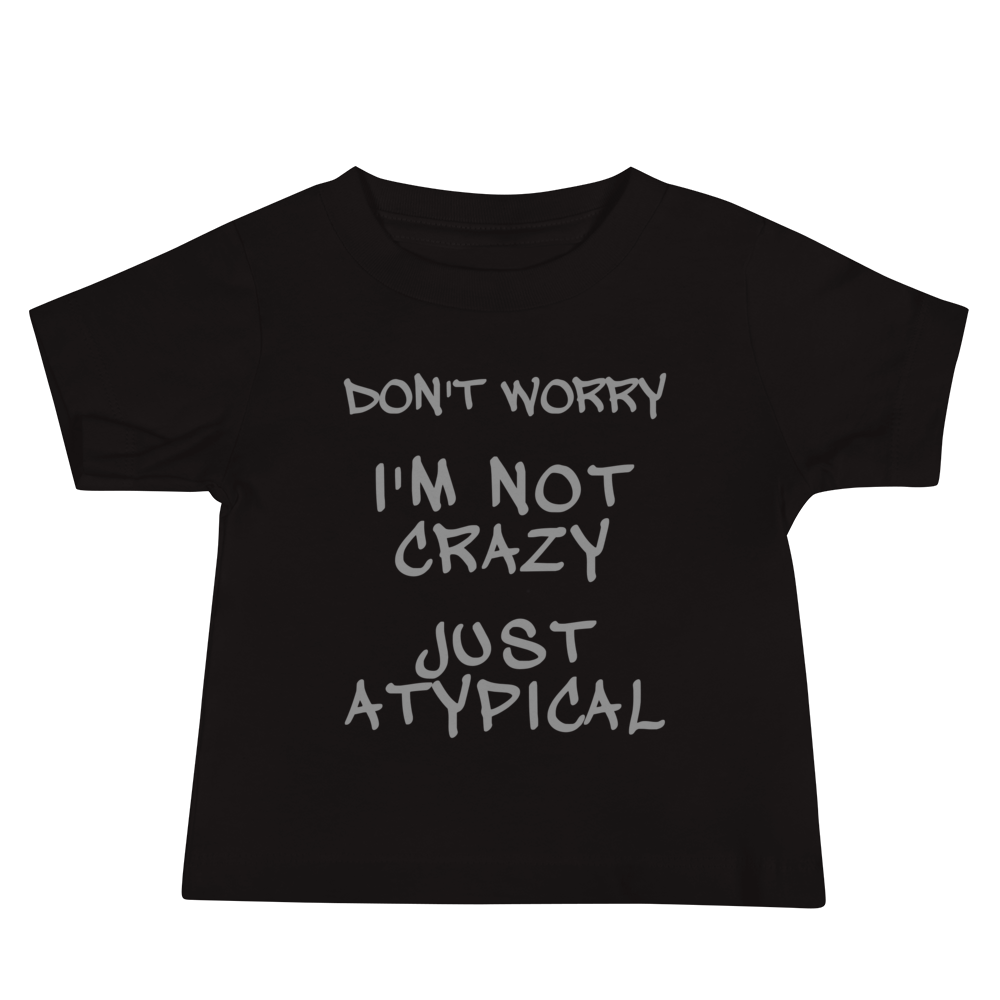"Don't Worry I'm Not Crazy Just Atypical" printed on a black baby jersey short sleeve tee laying on a flat surface