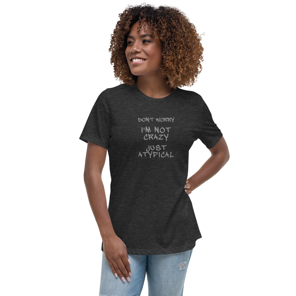 "Don't Worry I'm Not Crazy Just Atypical" printed on a dark grey heather women's relaxed t-shirt worn by a female