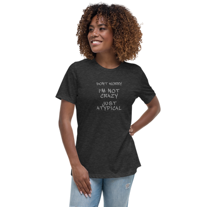 "Don't Worry I'm Not Crazy Just Atypical" printed on a dark grey heather women's relaxed t-shirt worn by a female
