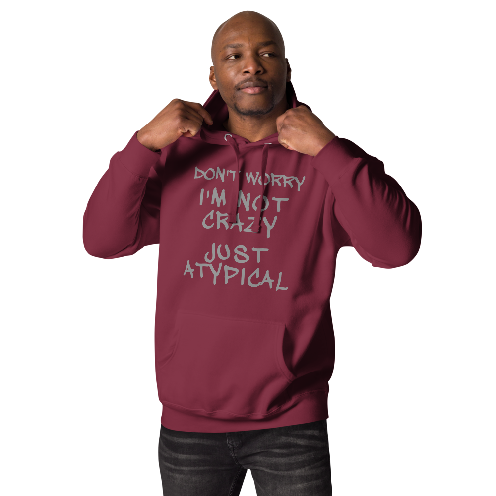 "Don't Worry I'm Not Crazy Just Atypical" printed on a maroon unisex hoodie worn by a male
