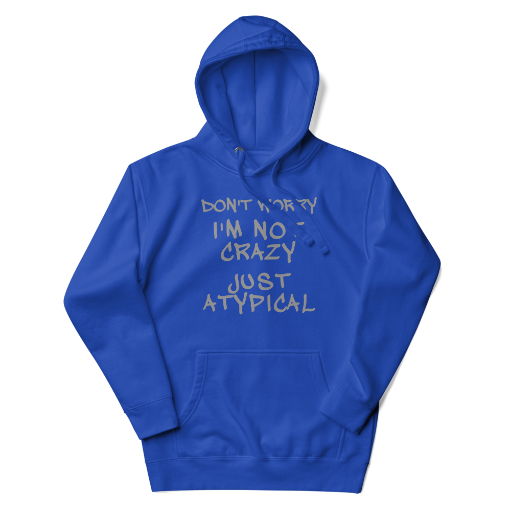 "Don't Worry I'm Not Crazy Just Atypical" printed on a team royal unisex hoodie laying on a flat surface with the hood up