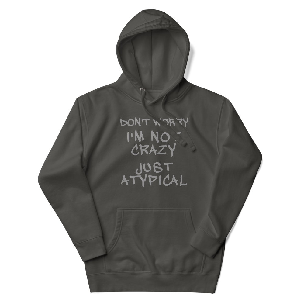 "Don't Worry I'm Not Crazy Just Atypical" printed on a vintage black unisex hoodie laying on a flat surface with the hood up
