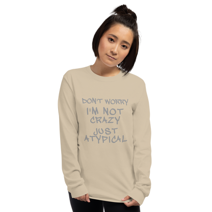 "Don't Worry I'm Not Crazy Just Atypical" printed on a sand men's long sleeve shirt worn by a female