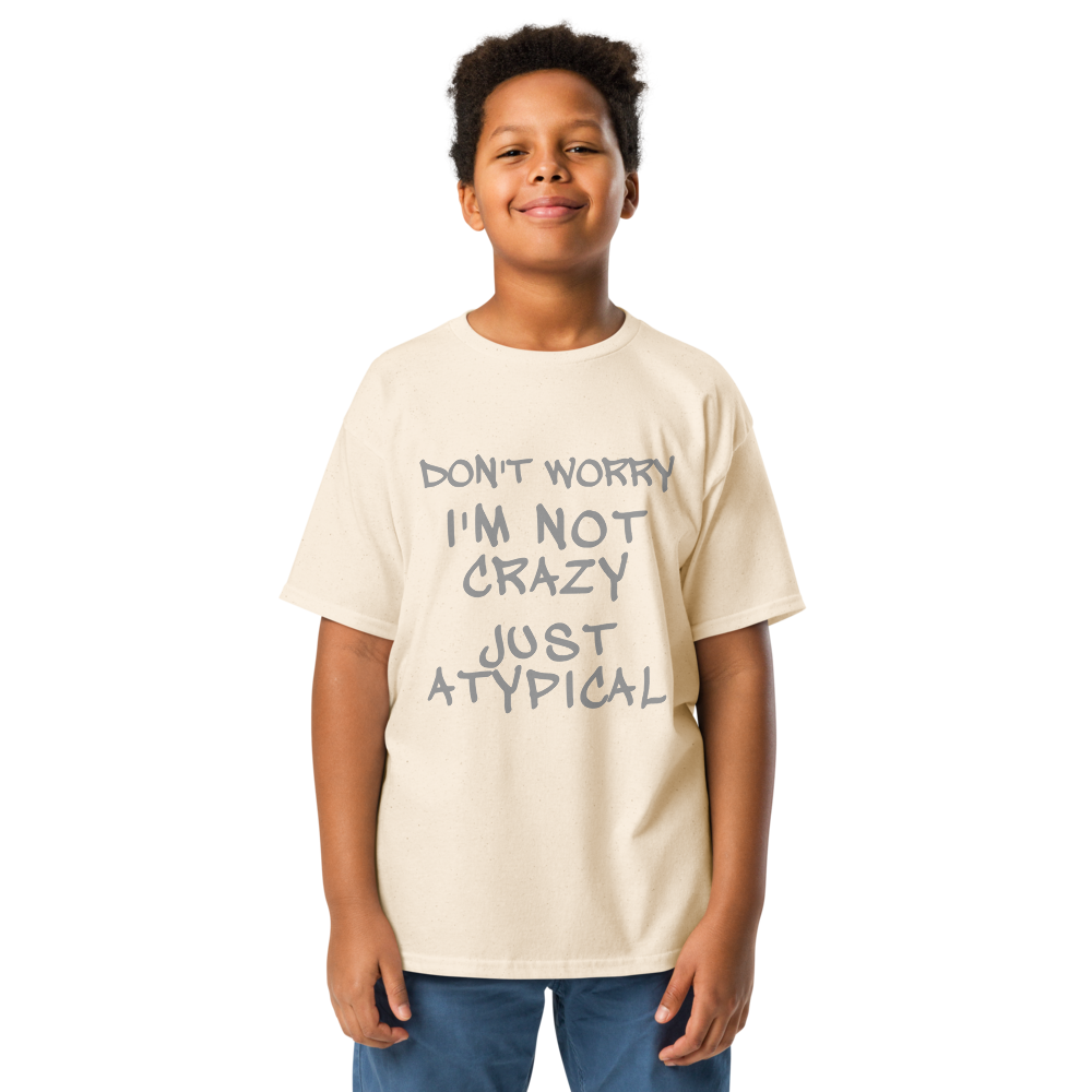 "Don't Worry I'm Not Crazy Just Atypical" printed on a natural youth classic tee worn by a male