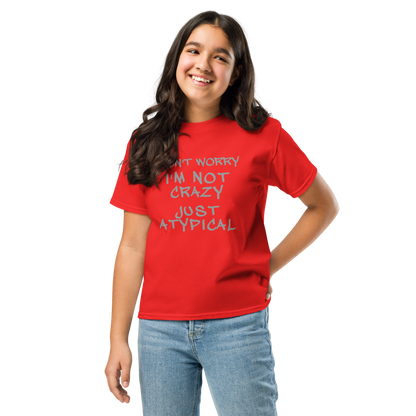 "Don't Worry I'm Not Crazy Just Atypical" printed on a red youth classic tee worn by a female