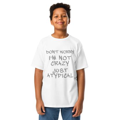 "Don't Worry I'm Not Crazy Just Atypical" printed on a white youth classic tee worn by a male