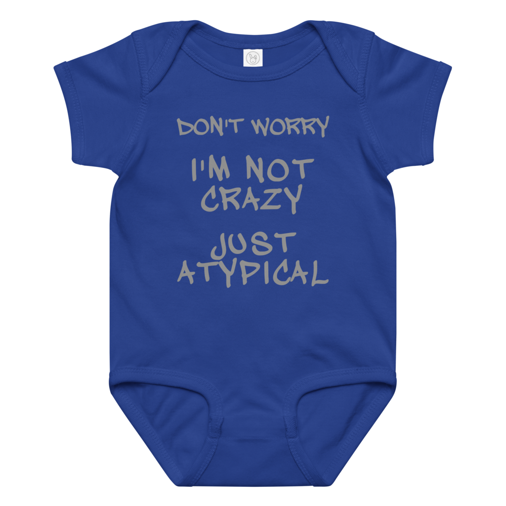 "Don't Worry I'm Not Crazy Just Atypical" printed on a royal baby jersey bodysuit laying on a flat surface amongst other clothes