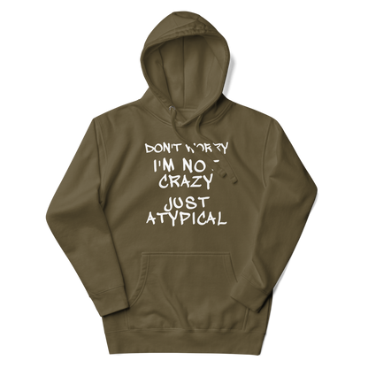 "Don't Worry I'm Not Crazy Just Atypical" printed on a military green unisex hoodie laying on a flat surface with the hood up