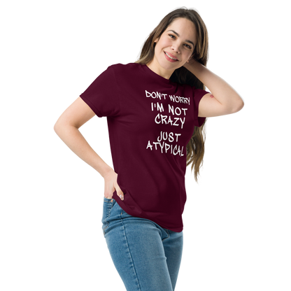 "Don't Worry I'm Not Crazy Just Atypical" printed on a maroon unisex classic tee worn by a female