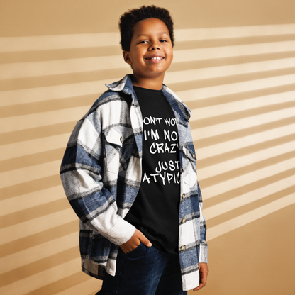 "Don't Worry I'm Not Crazy Just Atypical" printed on a black youth classic tee worn by a male also wearing a jacket