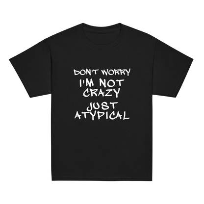 "Don't Worry I'm Not Crazy Just Atypical" printed on a black youth classic tee laying on a flat surface