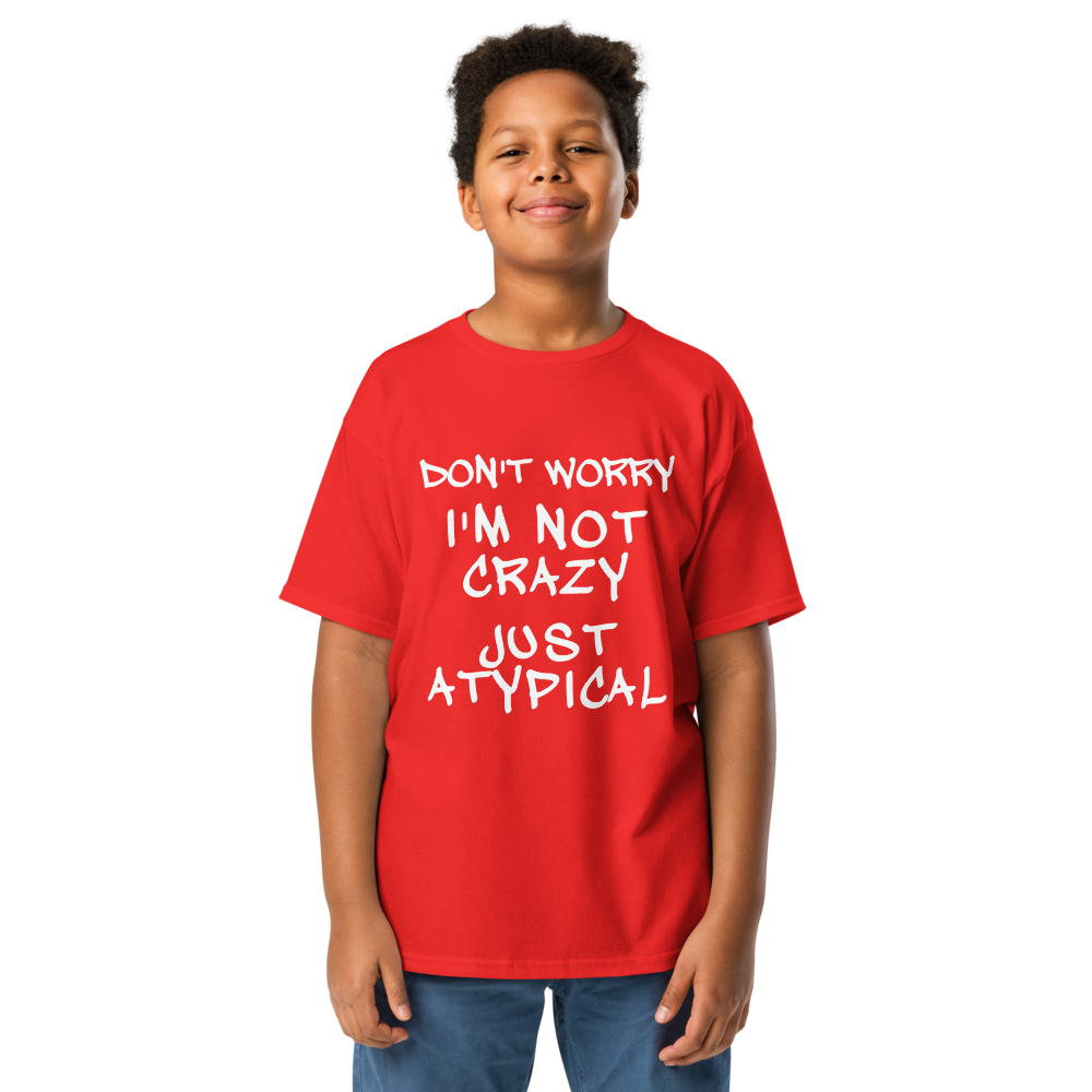 "Don't Worry I'm Not Crazy Just Atypical" printed on a red youth classic tee worn by a male