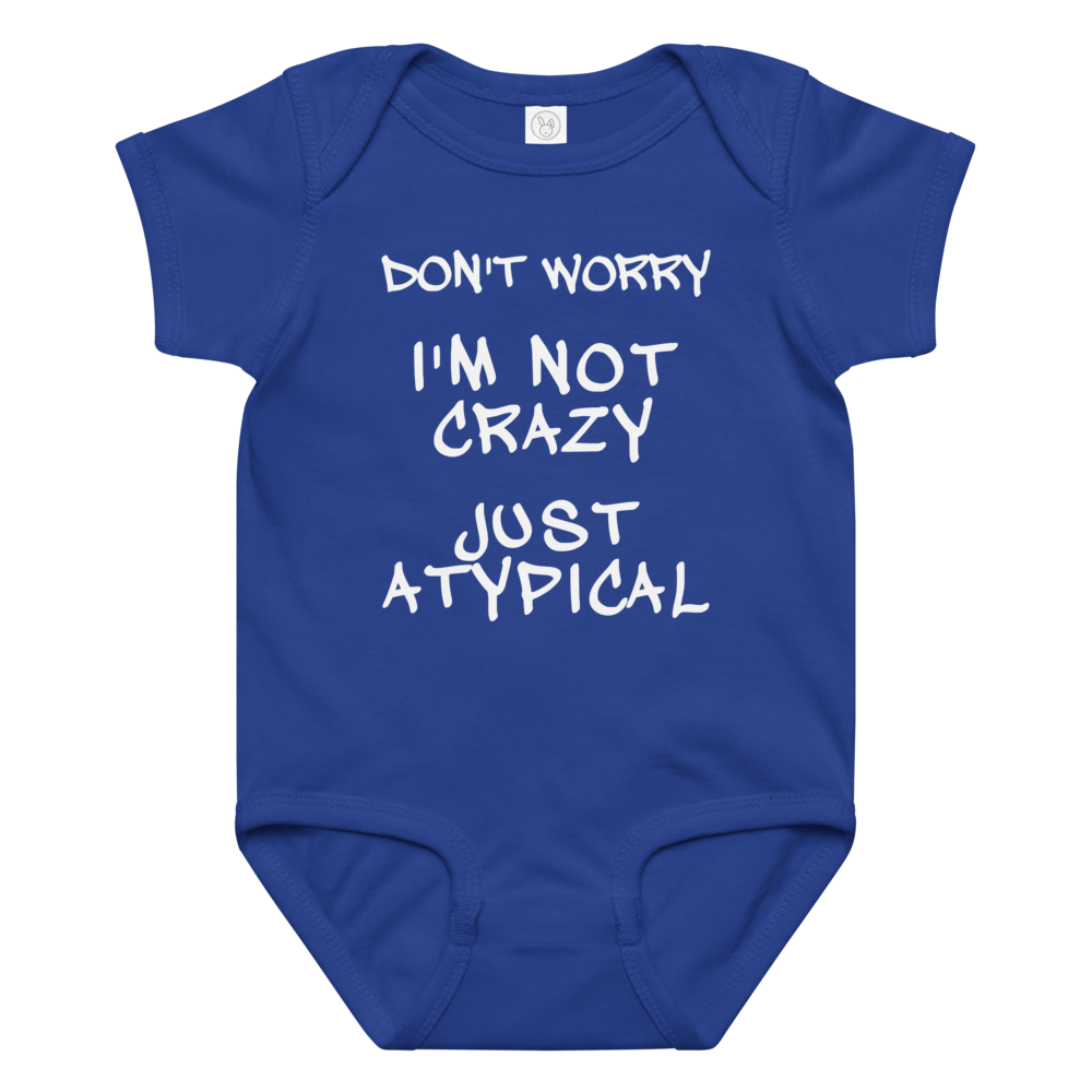 "Don't Worry I'm Not Crazy Just Atypical" printed on a royal baby jersey bodysuit laying on a flat surface amongst other clothes