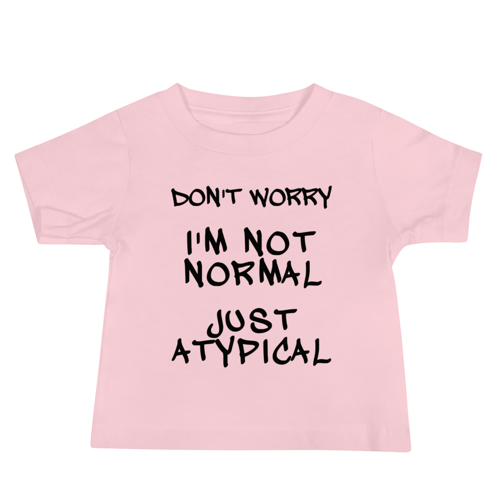 "Don't Worry I'm Not Normal Just Atypical" printed on a pink baby jersey short sleeve tee laying on a flat surface