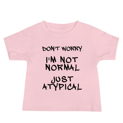 "Don't Worry I'm Not Normal Just Atypical" printed on a pink baby jersey short sleeve tee laying on a flat surface