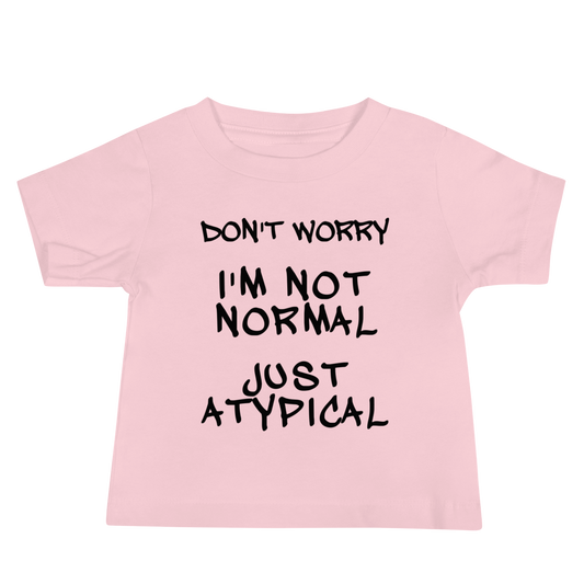 "Don't Worry I'm Not Normal Just Atypical" printed on a pink baby jersey short sleeve tee laying on a flat surface
