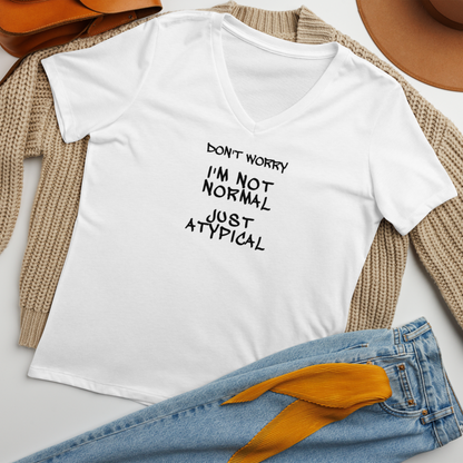 "Don't Worry I'm Not Normal Just Atypical" printed on a solid white blend women's relaxed v-neck t-shirt laying on a flat surface amongst other clothes