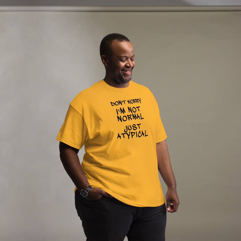 "Don't Worry I'm Not Normal Just Atypical" printed on a gold unisex classic tee worn by a male