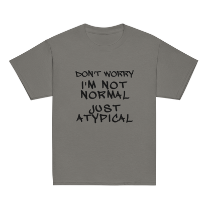 "Don't Worry I'm Not Normal Just Atypical" printed on a charcoal youth classic tee laying on a flat surface