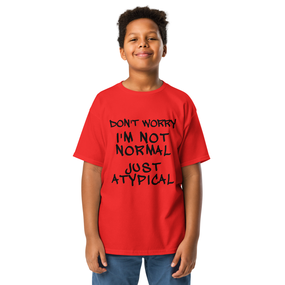 "Don't Worry I'm Not Normal Just Atypical" printed on a red youth classic tee worn by a male